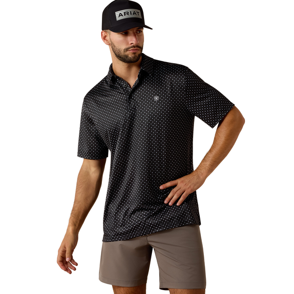 Man wearing a black patterned shirt and beige shorts with a white background
