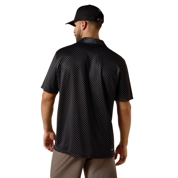Man wearing a black patterned shirt and cap on a white background