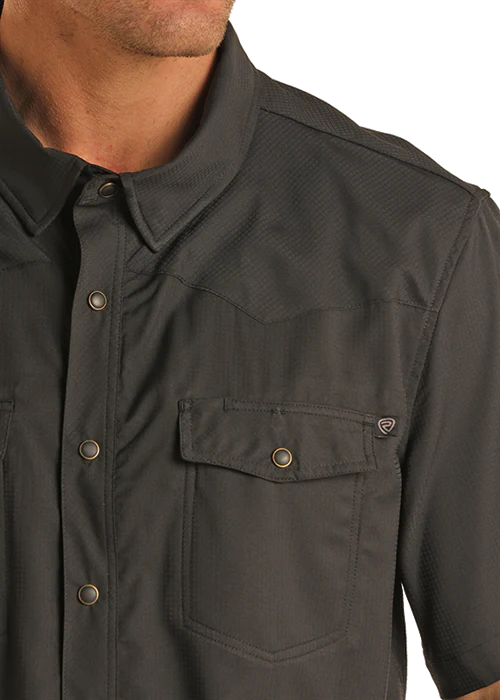 Close-up of a dark gray shirt with a pocket and buttons on a white background