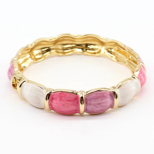 Gold bracelet with pink and white beads on a white background