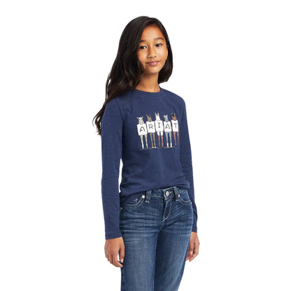 Girl wearing navy long sleeve graphic tee with horses and ARIAT lettering, paired with jeans