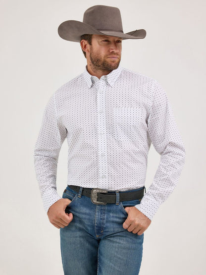 Man wearing grey cowboy hat, white patterned button-up shirt, and blue jeans