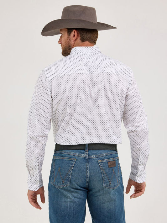 Man in grey cowboy hat, white patterned long sleeve shirt, and blue jeans, seen from behind.