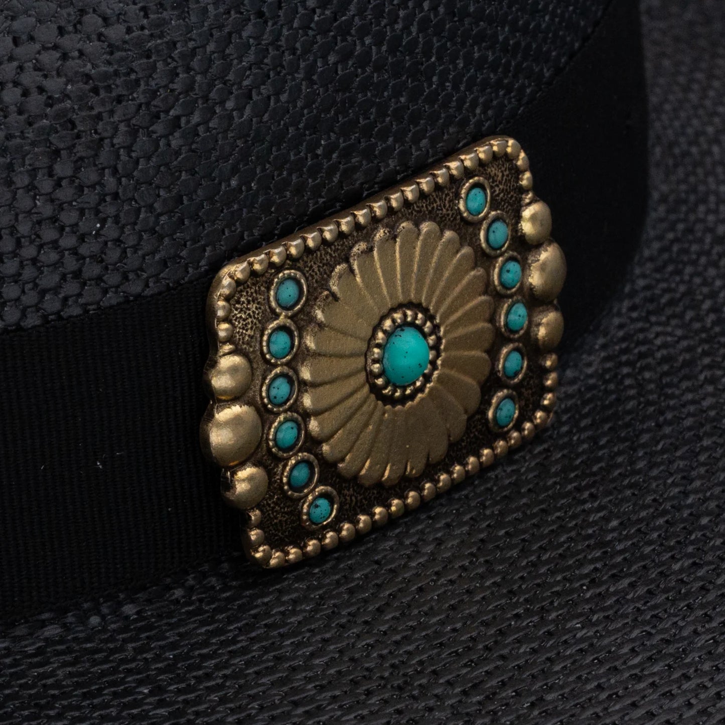 Decorative belt buckle with turquoise stones on a black background