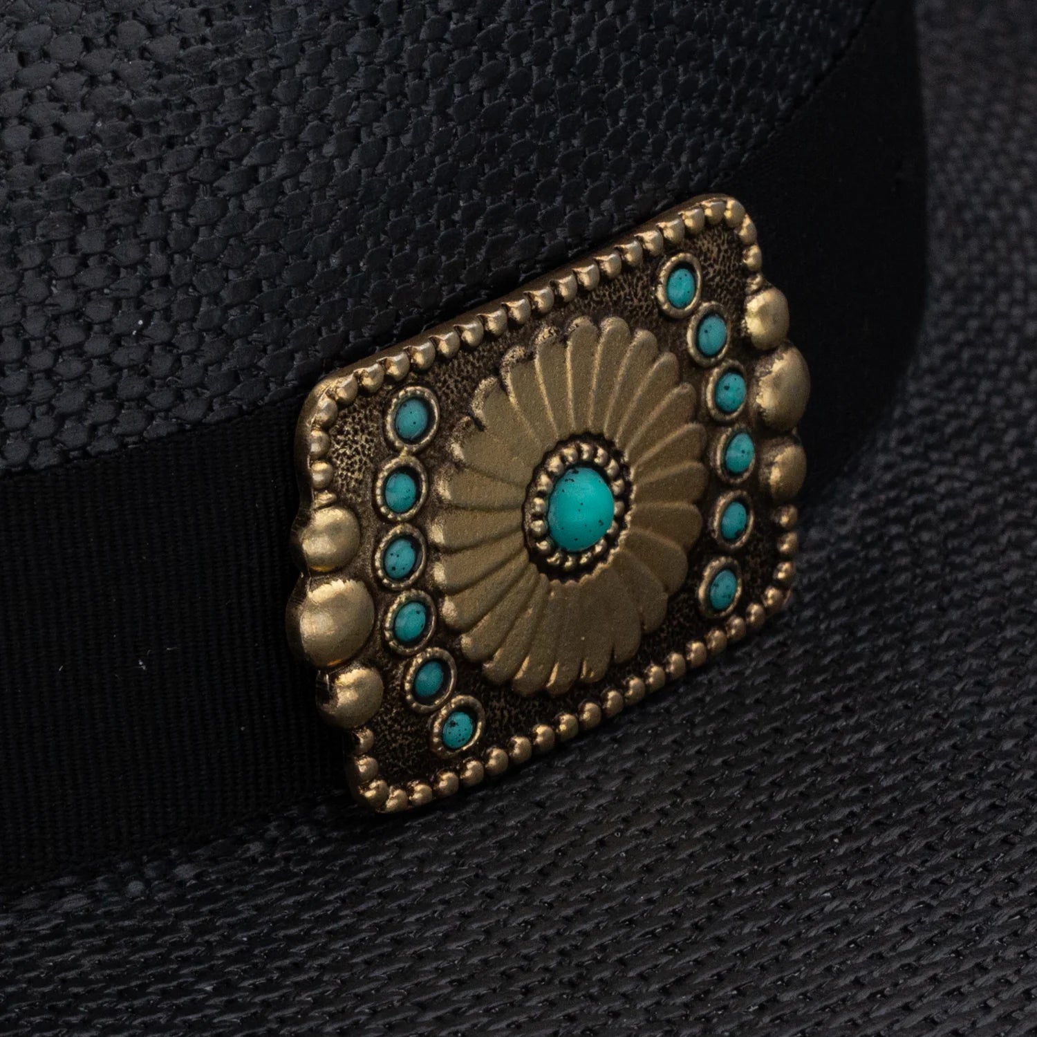 Decorative belt buckle with turquoise stones on a black background