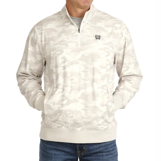 A man wearing a light beige and off-white camouflage quarter-zip pullover jacket with a small embroidered logo on the left chest, paired with blue jeans against a plain white background.