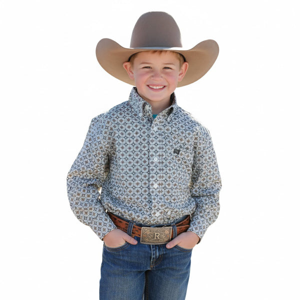 Smiling boy in patterned western shirt, cowboy hat, and jeans with belt buckle