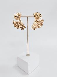 Gold earrings on a white stand with a white background