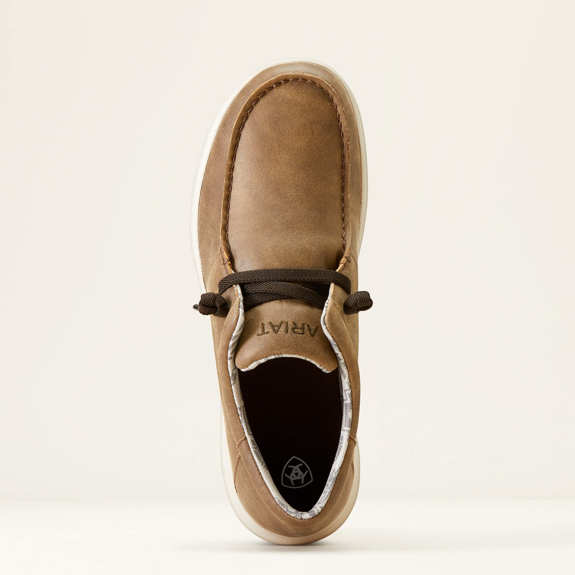 Brown leather casual shoe with white sole and dark laces, top view, on plain background