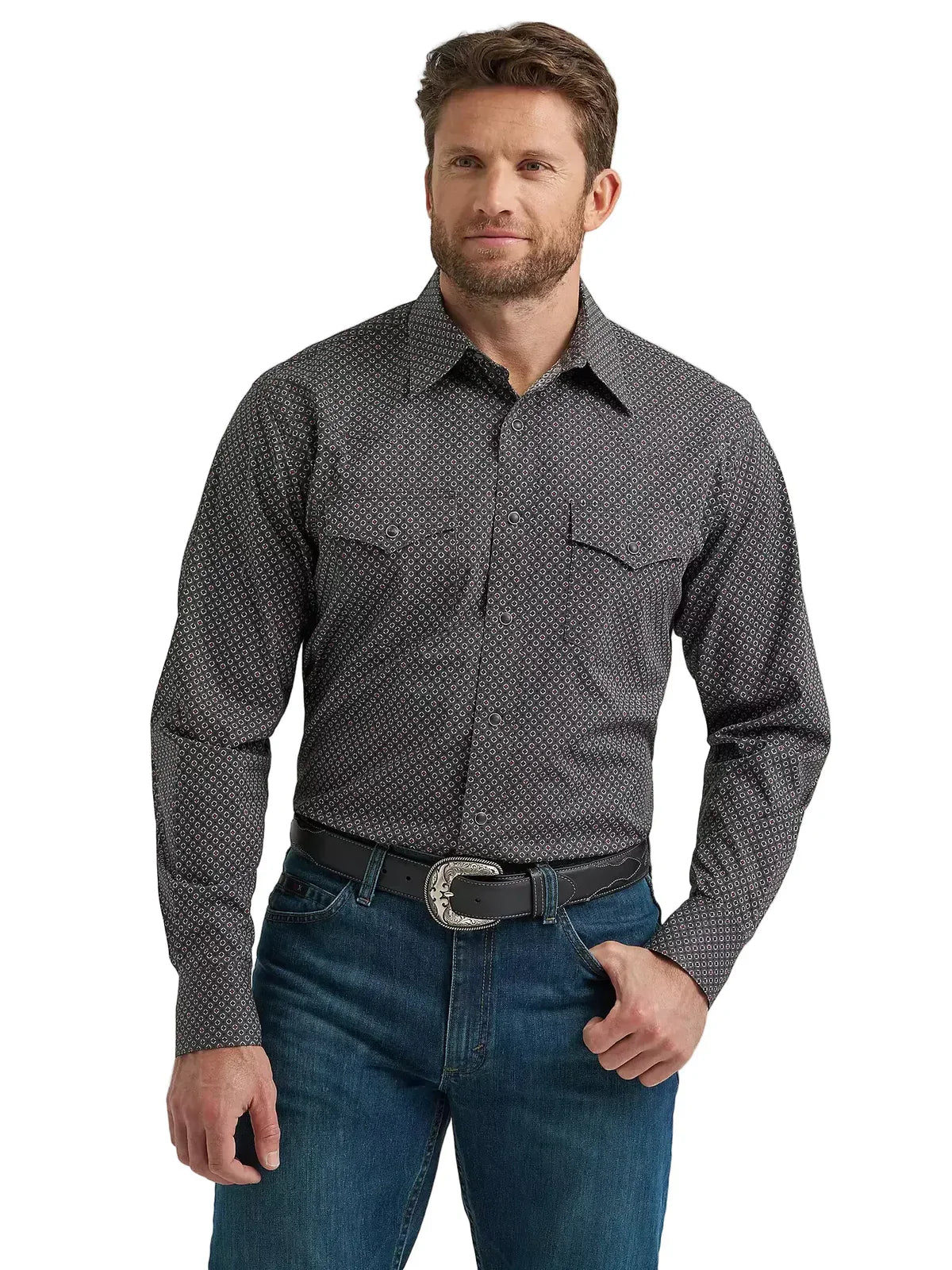 Man wearing a patterned long sleeve western shirt and blue jeans with a black belt buckle.