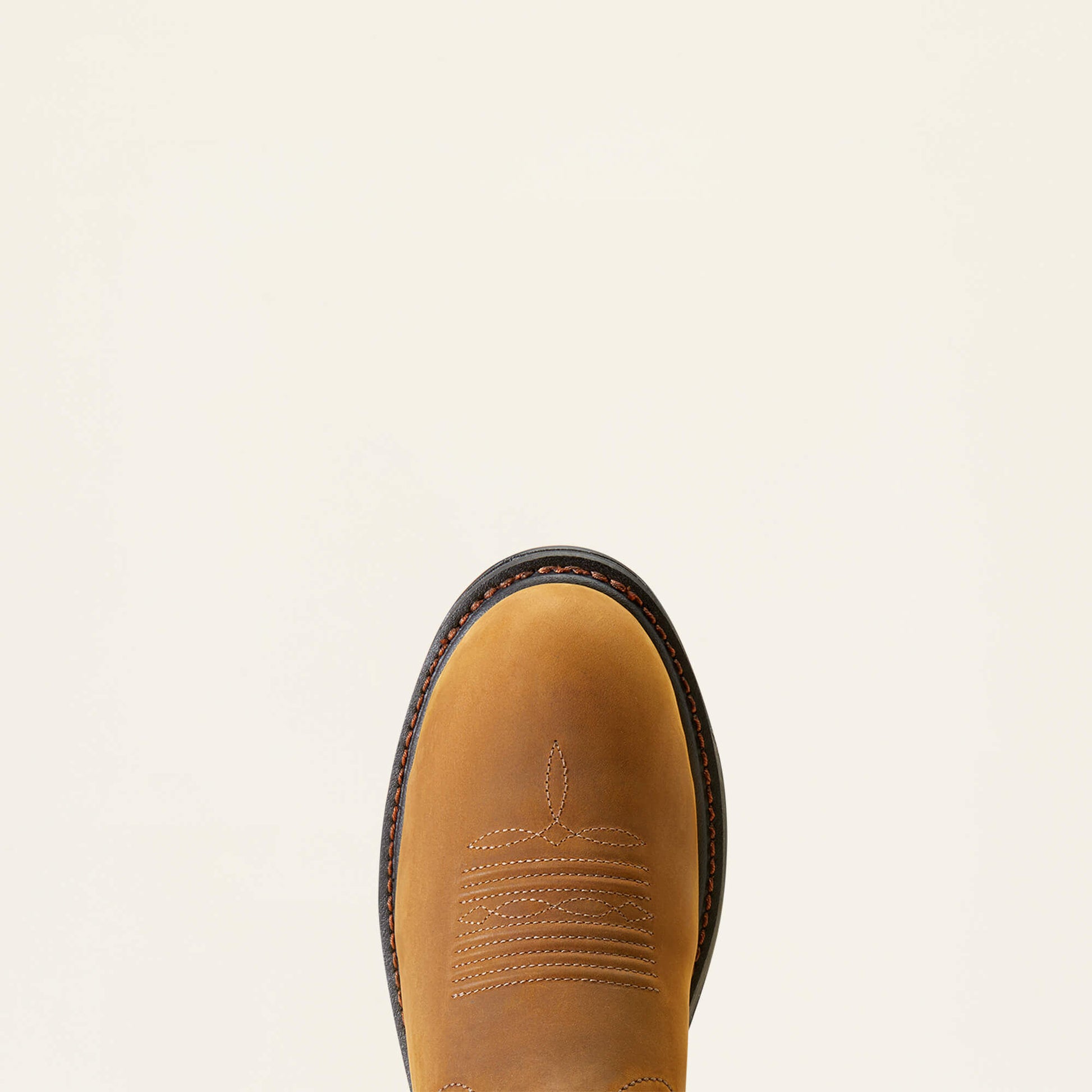 Close-up of a brown leather boot with stitching detail on a beige background
