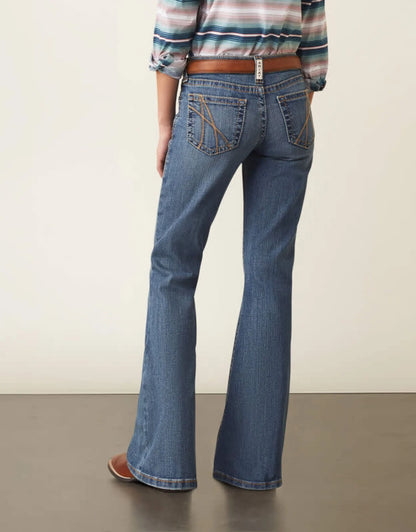 Woman wearing flare leg blue jeans with brown belt and striped top, back view