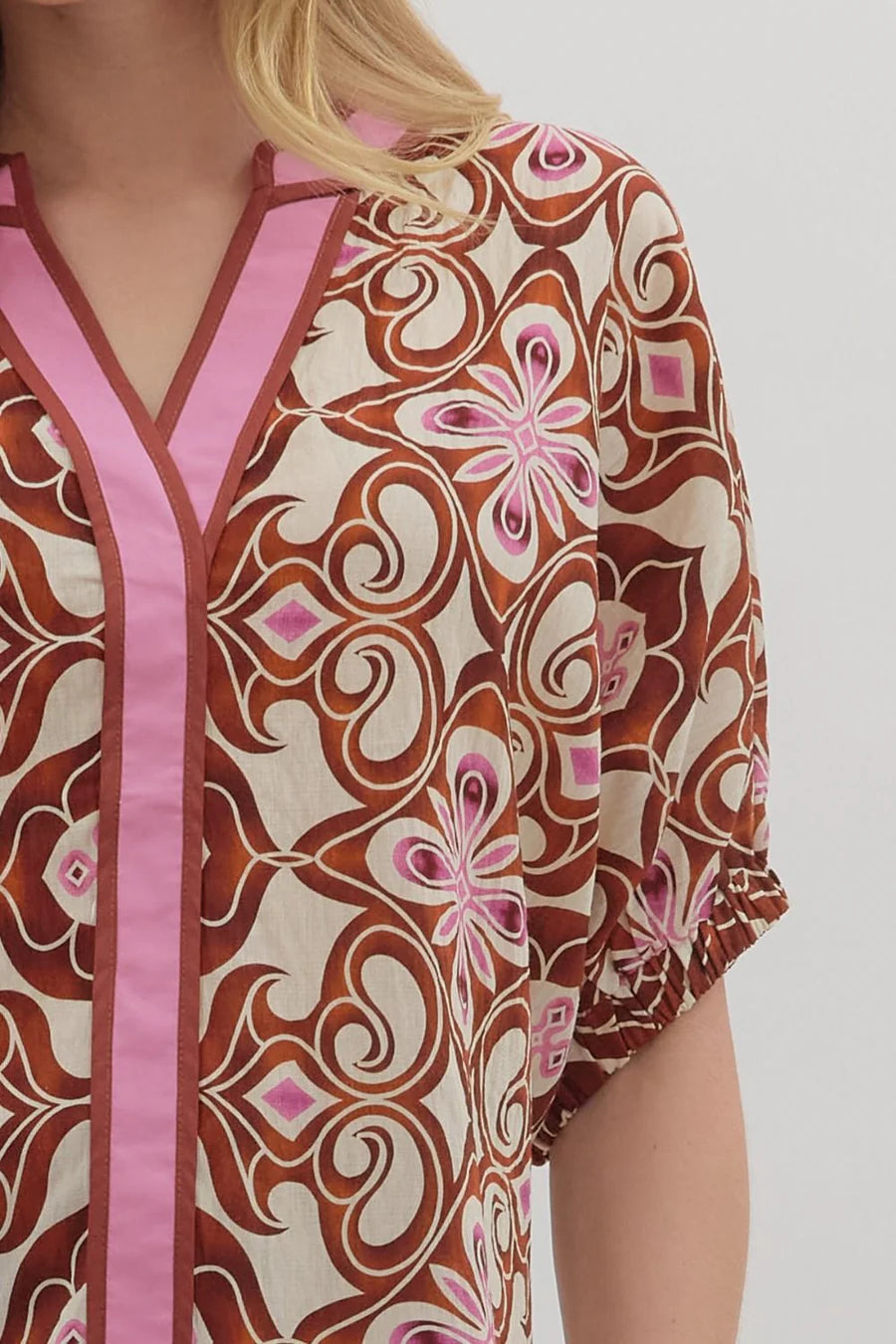 Patterned shirt with pink trim on a plain background