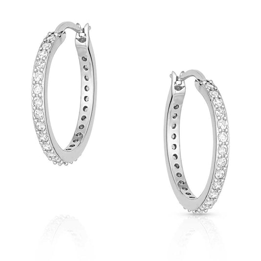 Silver hoop earrings with clear gemstones on a white background