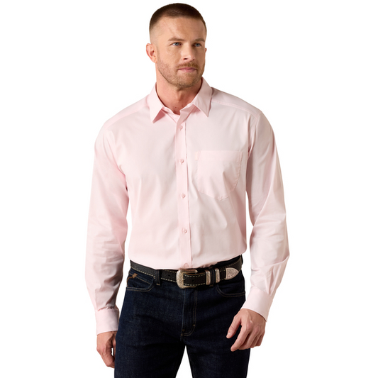Man wearing a light pink dress shirt and dark jeans on a white background