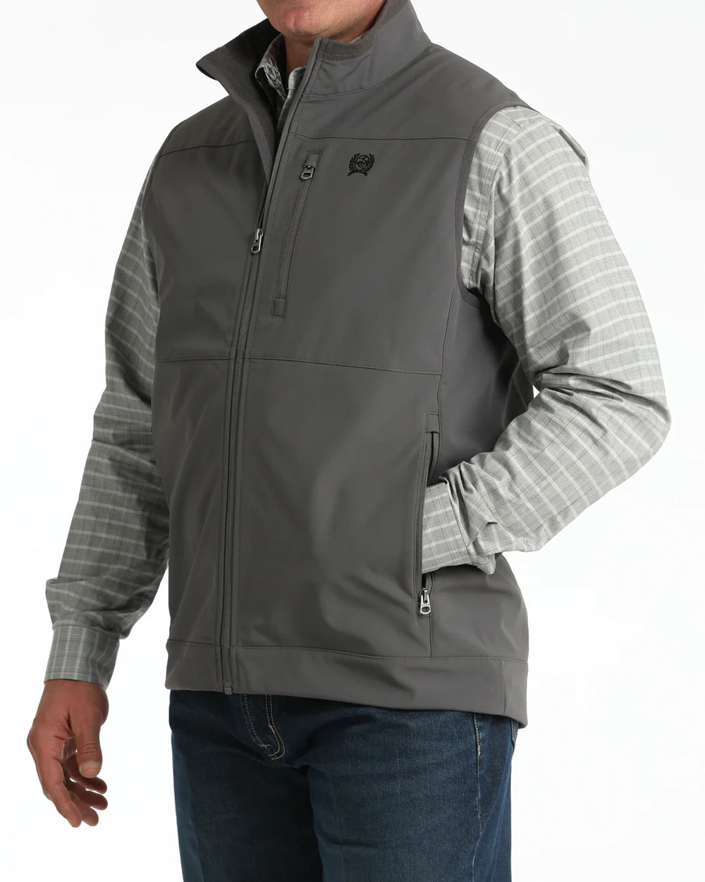 Men's gray softshell vest with zip pockets, worn over a plaid shirt and jeans