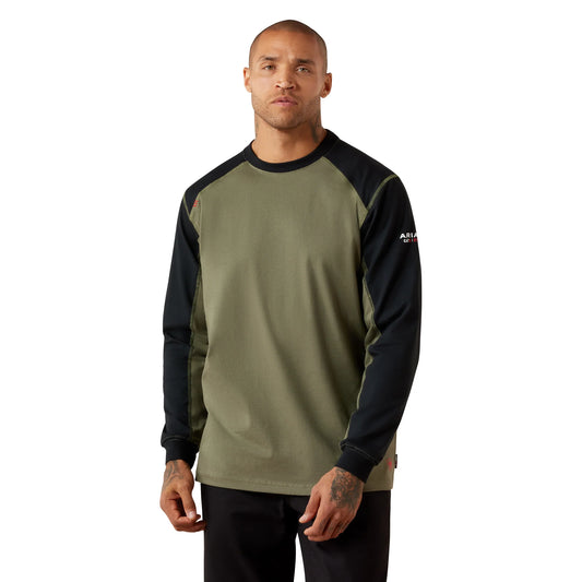 A man wearing a long-sleeve raglan shirt in olive green and black, with a small white logo on the left sleeve, photographed against a plain white background.