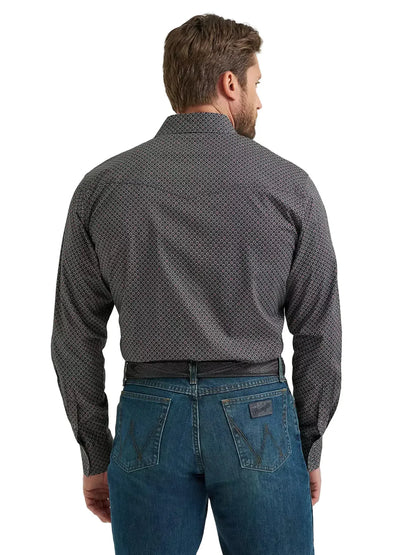 Man wearing patterned long sleeve shirt and blue jeans, shown from the back