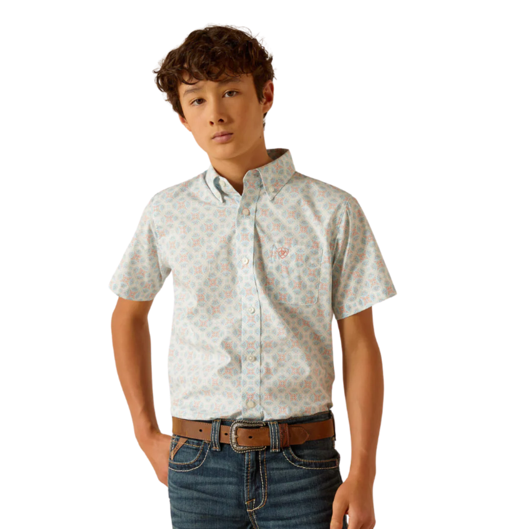 Boy wearing a short-sleeve patterned button-up shirt and jeans