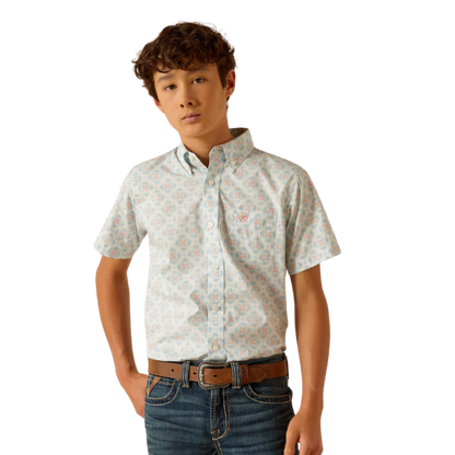 Boy wearing a short-sleeve patterned button-up shirt and jeans