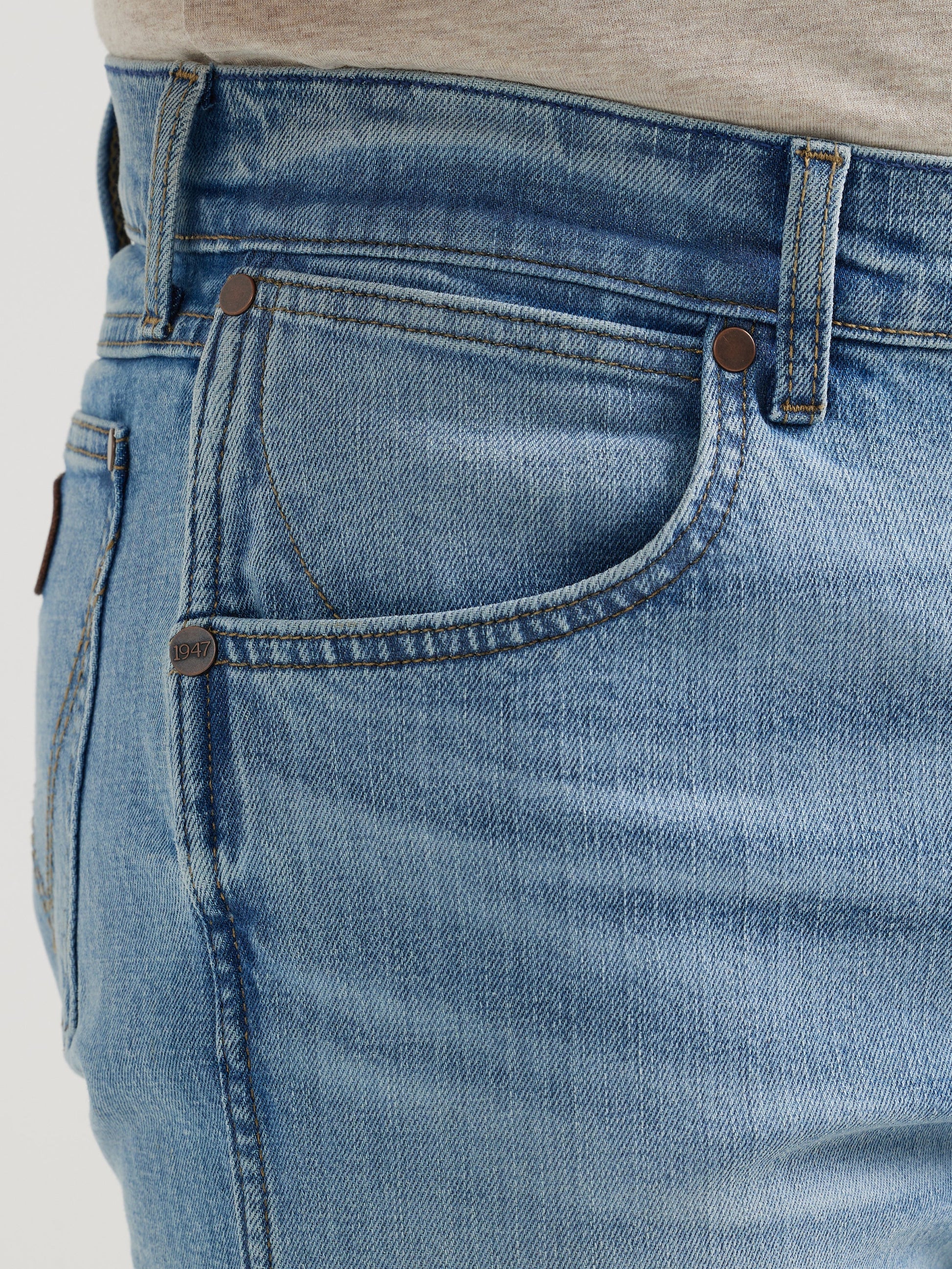 Close-up of light blue denim jeans front pocket and belt loop detail