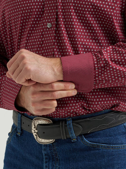 Burgundy men's long sleeve shirt with white dot pattern, paired with jeans and western belt.