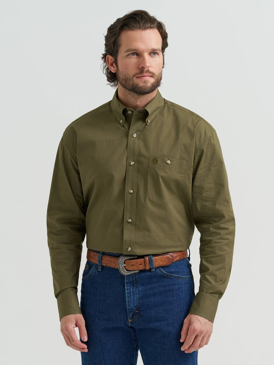 Man wearing an olive green button-up shirt and blue jeans on a white background