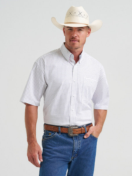 Man wearing a white short-sleeve shirt with a subtle pattern, blue jeans, and a beige cowboy hat on a light gray background.