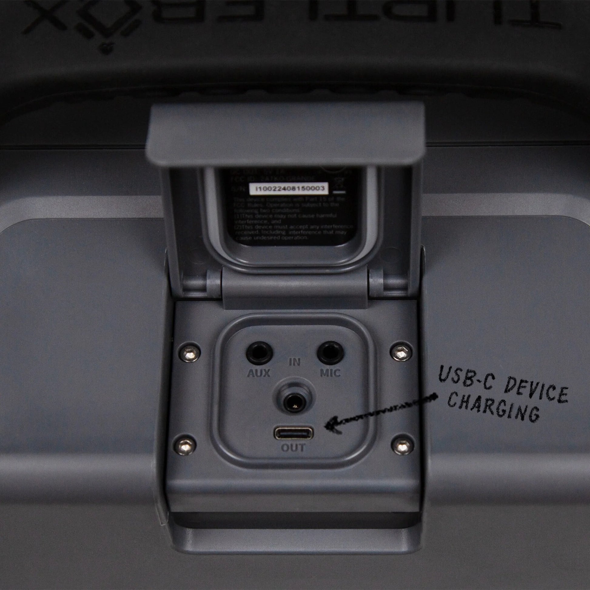 Close-up of a device charging port with labels on a dark background