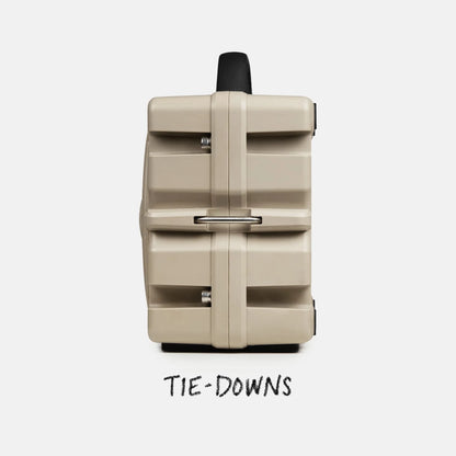 Beige suitcase with tie-downs feature on a white background
