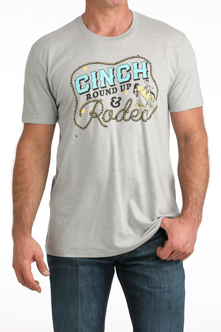 Man wearing a gray t-shirt with 'Ginch Round Up & Rodeo' graphic design.