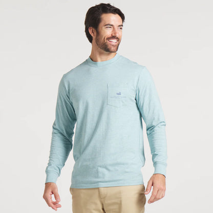 Man wearing light blue long sleeve crewneck shirt with chest pocket and khaki pants