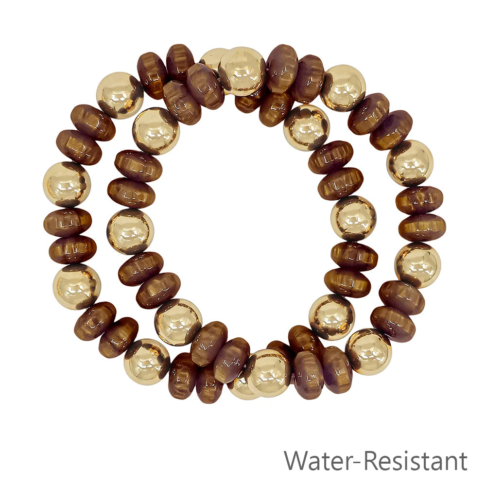 Water-resistant bracelet with alternating brown wood and gold beads on white background
