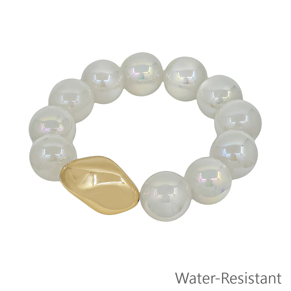White beaded stretchy bracelet with one gold accent bead, water-resistant jewelry