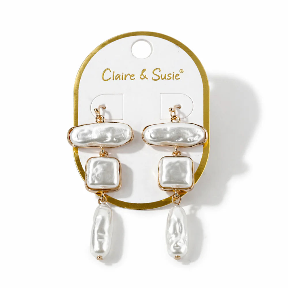 Pearl earrings on a Claire & Susie branded card against a white background