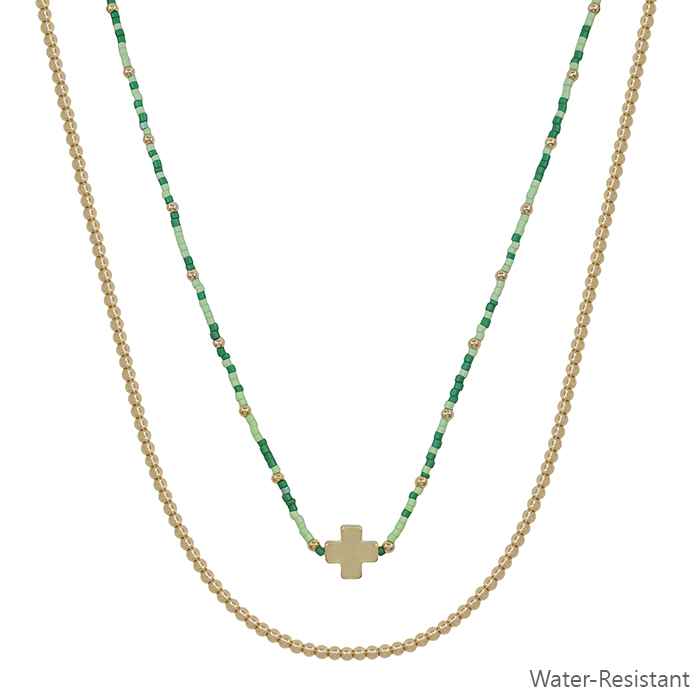 Two necklaces with green beaded chain and gold cross pendant on a white background.