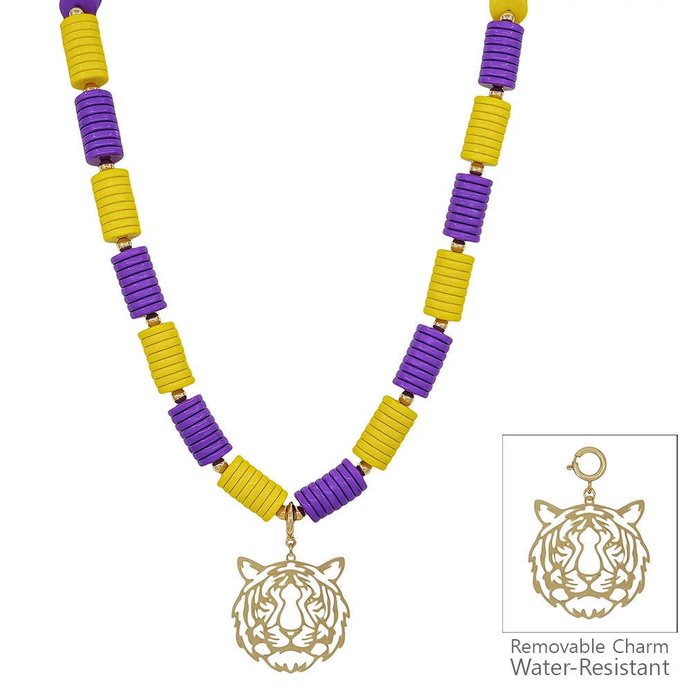 A beaded necklace with alternating purple and yellow cylindrical beads and a gold tiger head pendant, shown on a white background with a small inset showing the removable water-resistant charm.