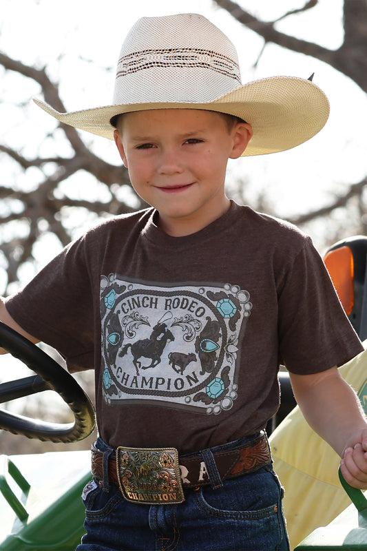 Child wearing a cowboy hat and t-shirt with a ranch rodeo champion design.