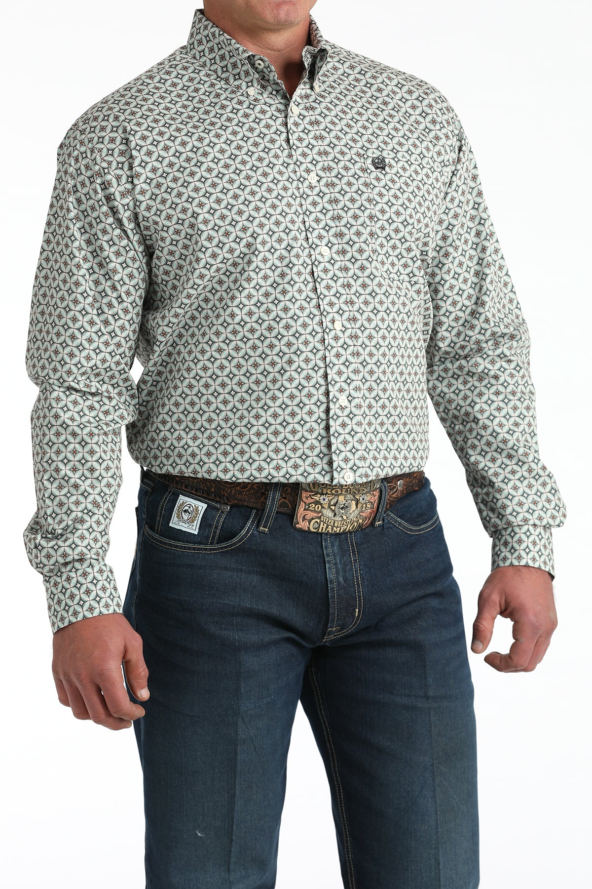 Men's geometric print button-down western shirt with blue jeans and rodeo belt buckle.