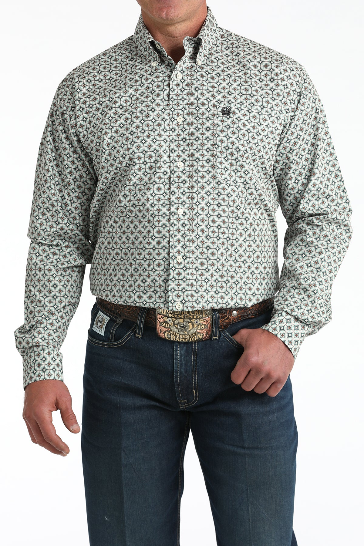 Man wearing geometric patterned button-up shirt and dark blue jeans