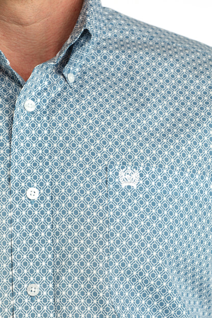 Close-up of blue geometric patterned button-up shirt with embroidered pocket logo