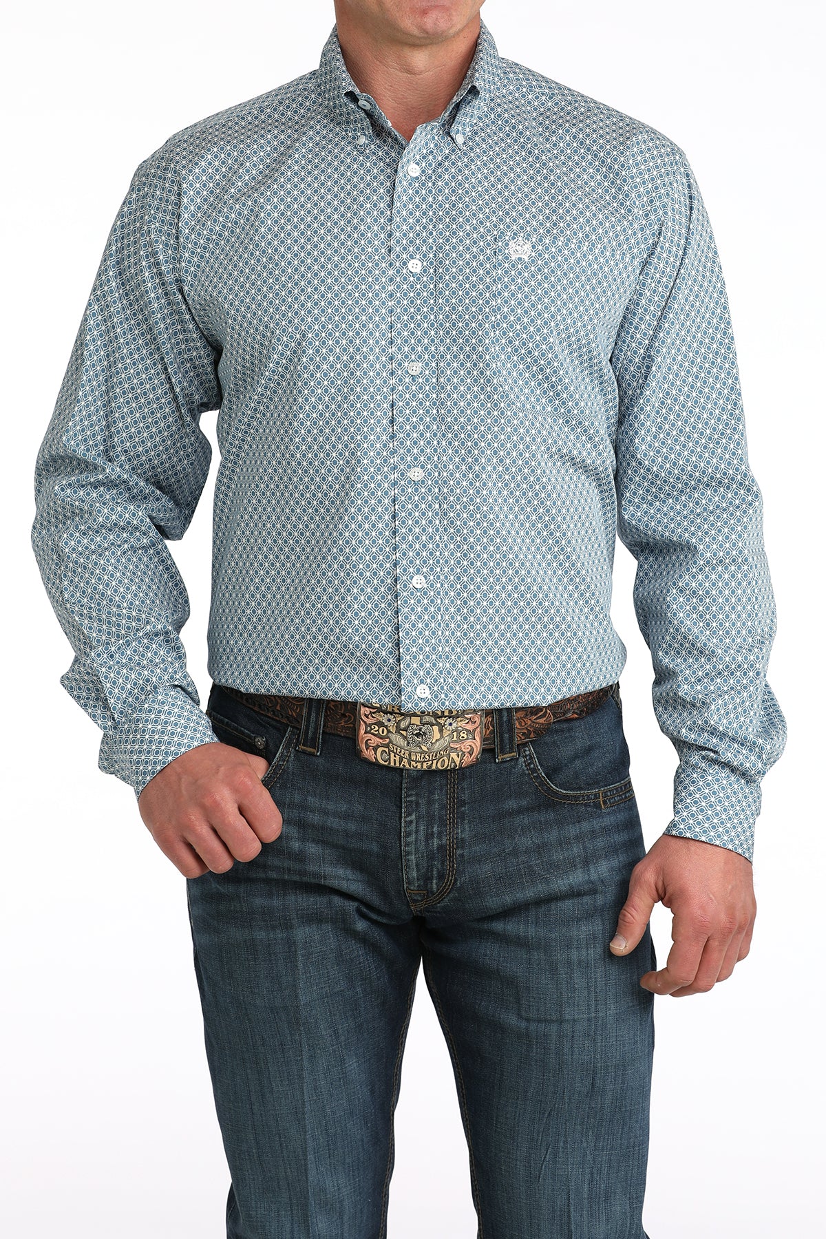 Men's blue geometric pattern long sleeve button-down western shirt with jeans and a large belt buckle.