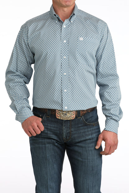 Men's blue geometric pattern long sleeve button-down western shirt with jeans and a large belt buckle.