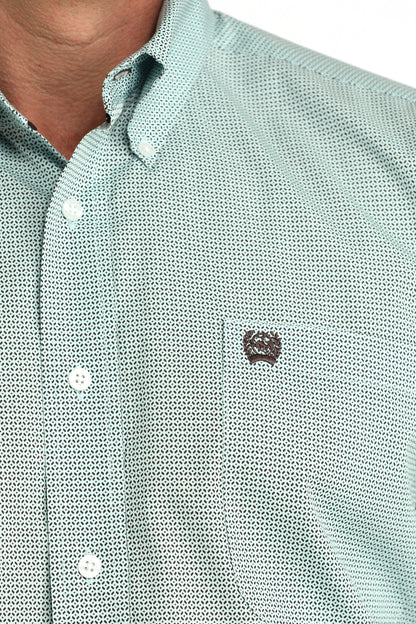 Close-up of a light green textured shirt with a small logo on a white background