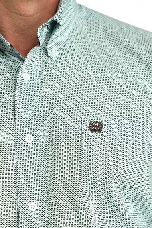 Close-up of a light green textured shirt with a small logo on a white background