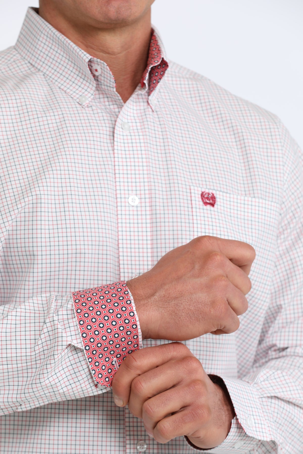 Close-up of a person wearing a checkered shirt with a red and white pattern on the cuffs.