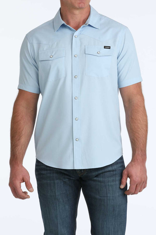 Light blue short-sleeve button-up shirt worn by a person on a white background