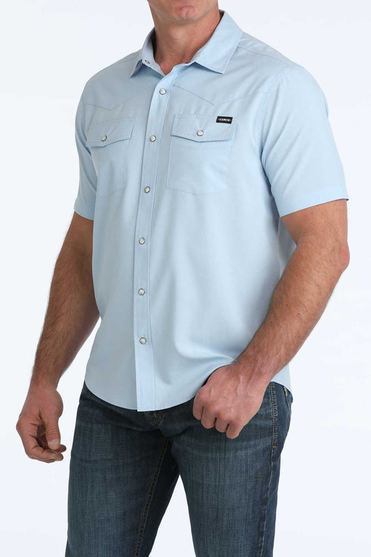 Light blue short-sleeve button-up shirt worn by a person on a white background
