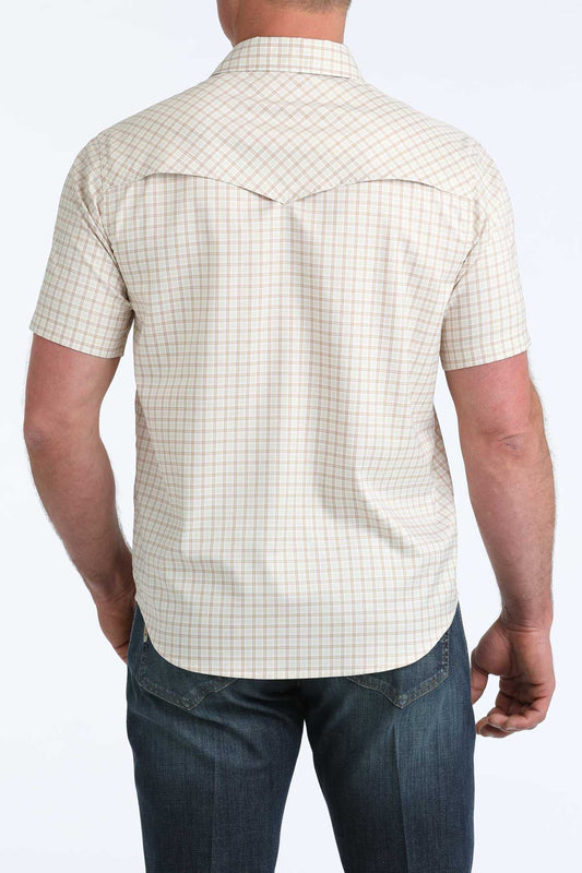 Person wearing a beige checkered shirt and blue jeans on a white background