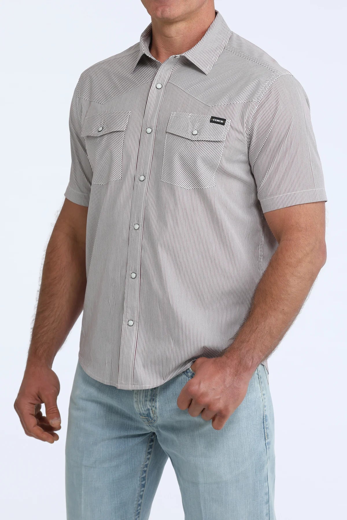 Man wearing a gray short-sleeve button-up shirt with a subtle pattern on a white background